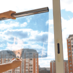 Photo d'un film solaire tenu devant une vitre